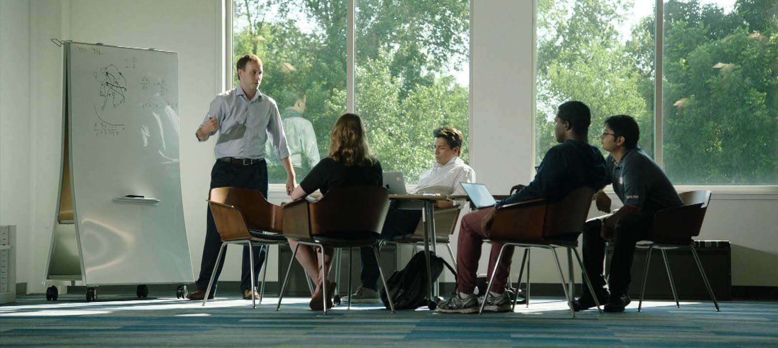 Weninger, in front of a white board illustrating networks, presents to a group of students.