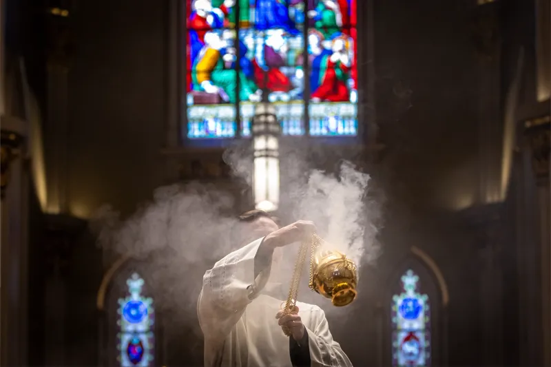 Smoke pours out of an urn during Evening Mass of the Lord's Supper at the Basilica of the Sacred Heart.