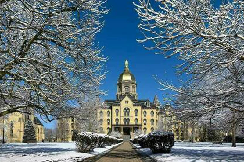 The snow-covered Golden Dome of the Main Building at the University of Notre Dame on a bright winter day.
